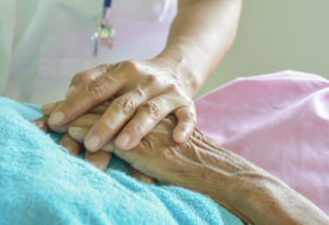 image of a nurse's hand touching a patient's hand
